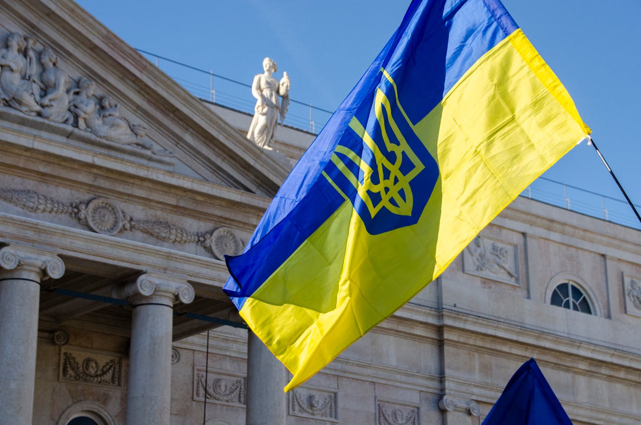 Ukrainian flag waving proudly in front of a historic Lisbon building under clear skies.